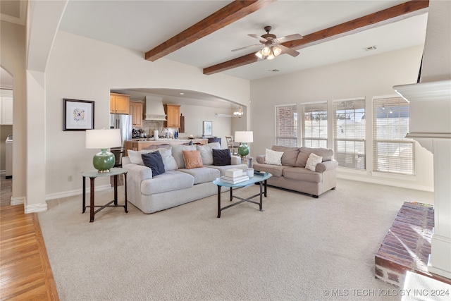 living room featuring beamed ceiling, ceiling fan, and light hardwood / wood-style flooring