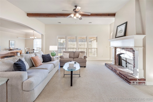 carpeted living room featuring beamed ceiling, ceiling fan with notable chandelier, and a brick fireplace