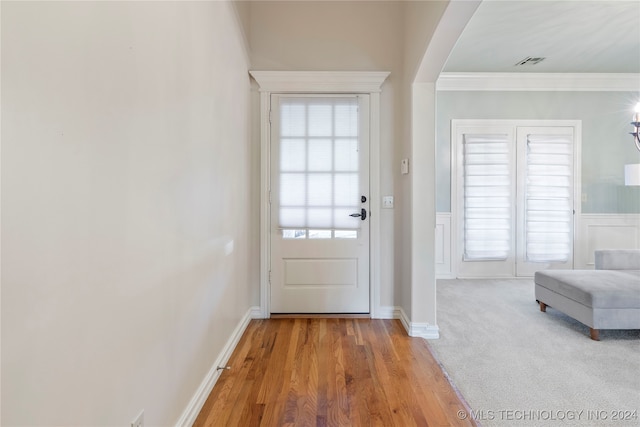 doorway to outside featuring light hardwood / wood-style floors and ornamental molding