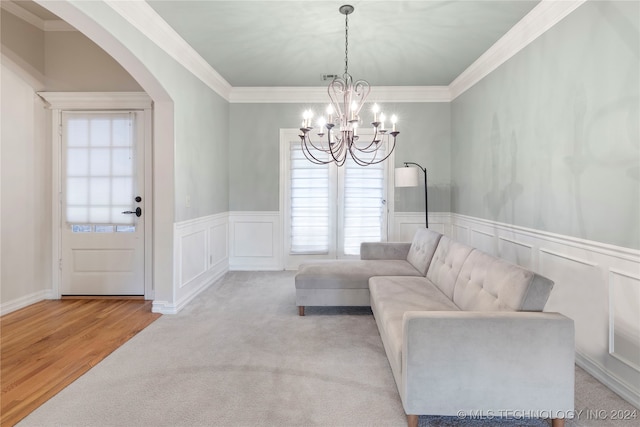 living room with crown molding, light hardwood / wood-style flooring, and a notable chandelier