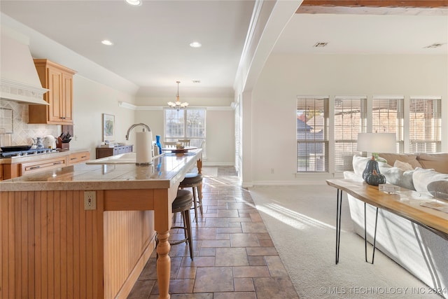 kitchen with tasteful backsplash, plenty of natural light, dark carpet, and custom exhaust hood