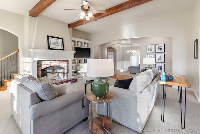 living room with light carpet, ceiling fan with notable chandelier, built in features, a fireplace, and beamed ceiling