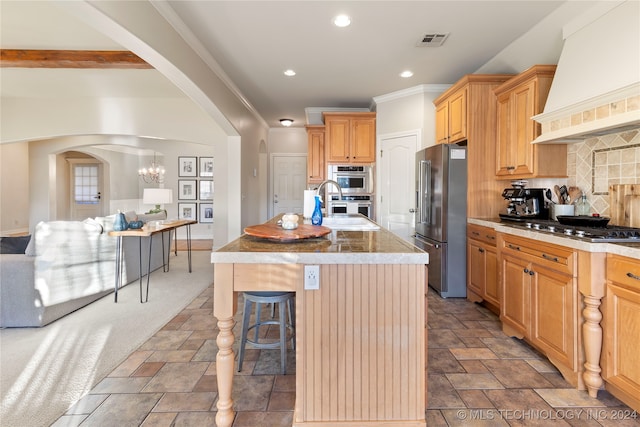 kitchen featuring backsplash, custom exhaust hood, stainless steel appliances, a kitchen island with sink, and a breakfast bar area