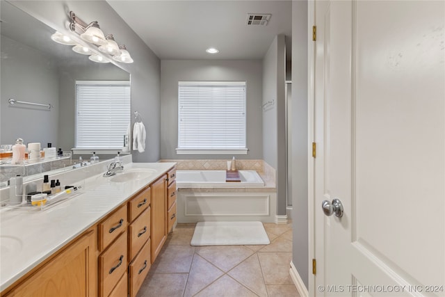 bathroom featuring tile patterned floors, a tub to relax in, and vanity