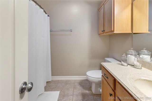 bathroom with tile patterned flooring, vanity, and toilet