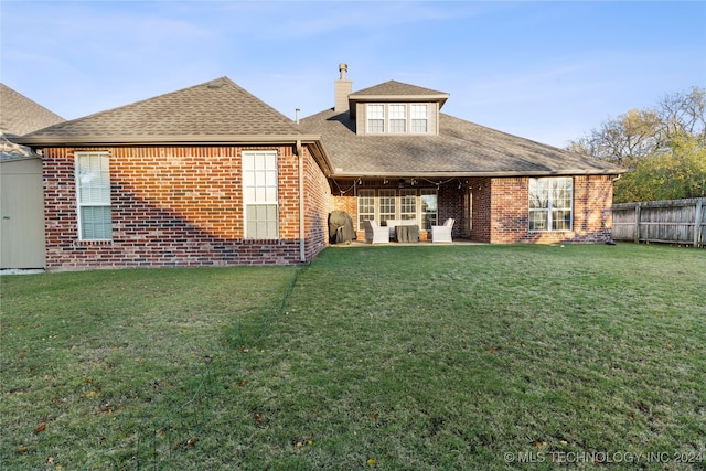 rear view of house featuring a yard