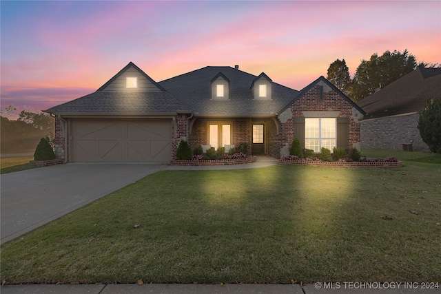 view of front of property featuring a yard and a garage