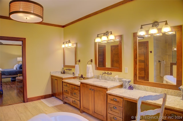 bathroom featuring tiled shower, vanity, hardwood / wood-style flooring, and ornamental molding