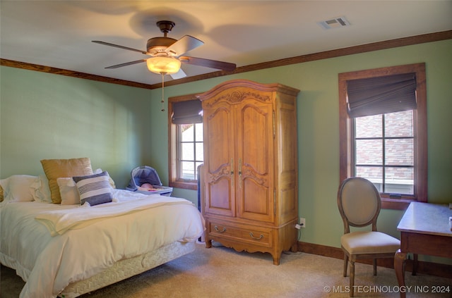 carpeted bedroom with ceiling fan and ornamental molding