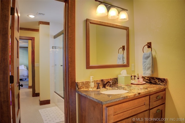 bathroom with shower / bath combination with glass door, vanity, and ornamental molding