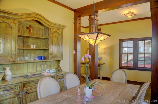 dining space with beamed ceiling and ornamental molding