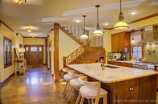 kitchen with ventilation hood, a center island with sink, sink, tasteful backsplash, and decorative light fixtures