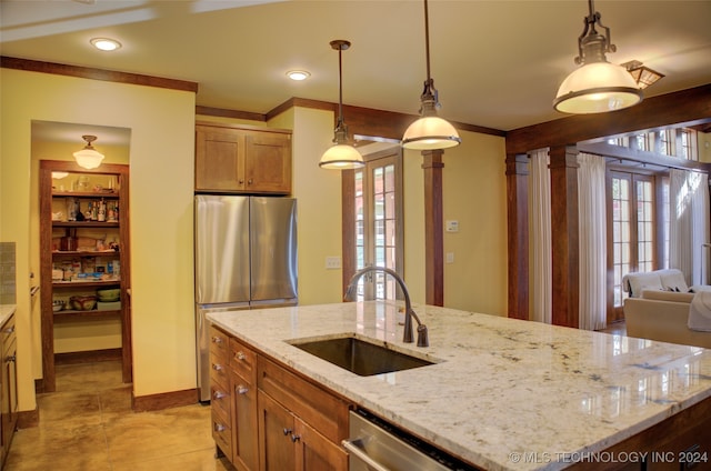 kitchen featuring light stone countertops, sink, decorative light fixtures, and appliances with stainless steel finishes