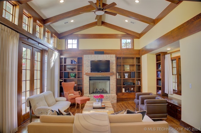 living room featuring high vaulted ceiling, a brick fireplace, ceiling fan, beam ceiling, and wood-type flooring