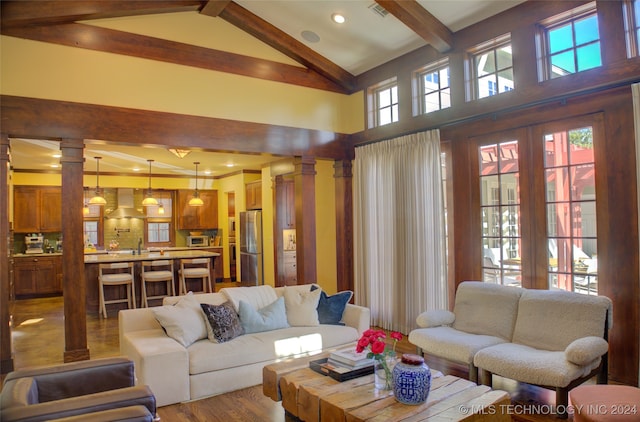 living room featuring ornate columns, sink, hardwood / wood-style flooring, high vaulted ceiling, and beamed ceiling