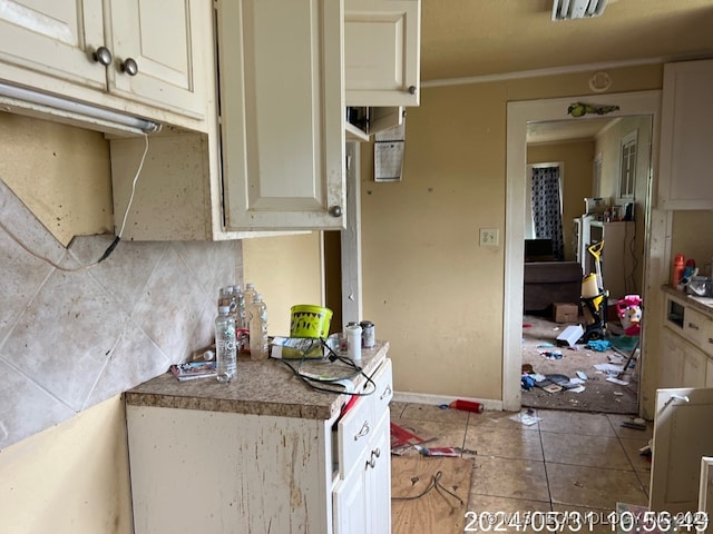 kitchen with tile patterned floors, cream cabinets, and tasteful backsplash