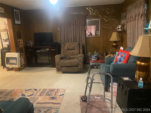 carpeted living room featuring wood walls, a textured ceiling, and heating unit