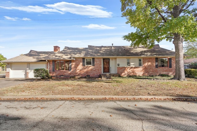 single story home with a front yard and a garage