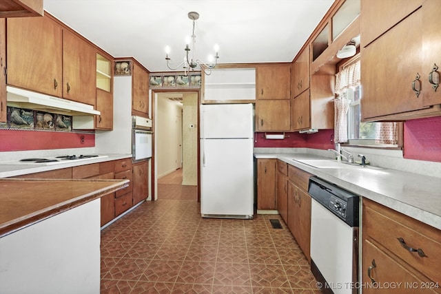 kitchen with a chandelier, sink, decorative light fixtures, and white appliances