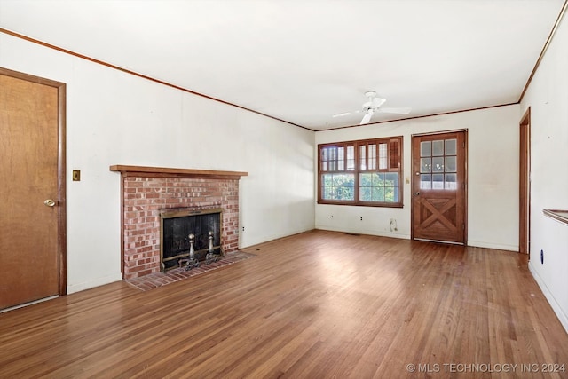 unfurnished living room featuring a fireplace, hardwood / wood-style flooring, ceiling fan, and ornamental molding