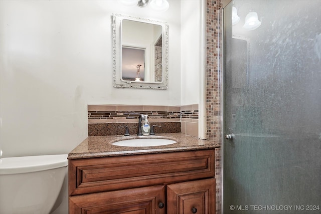 bathroom featuring backsplash, vanity, and toilet