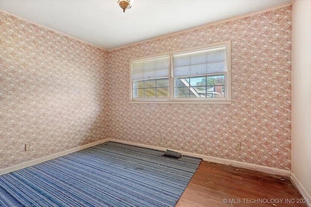 spare room featuring dark hardwood / wood-style flooring and ornamental molding