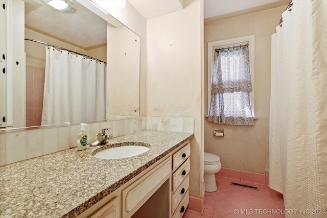 bathroom with toilet, vanity, and tile patterned floors