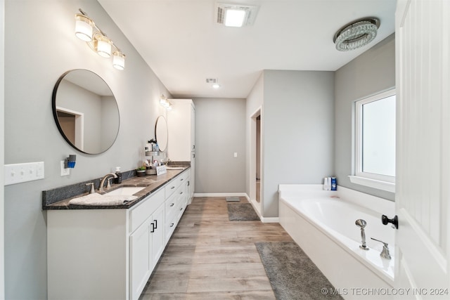 bathroom featuring a bath, wood-type flooring, and vanity