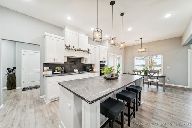 kitchen with a center island, white cabinets, and light hardwood / wood-style flooring