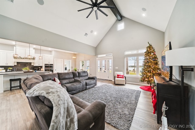 living room with beam ceiling, high vaulted ceiling, light hardwood / wood-style flooring, and ceiling fan