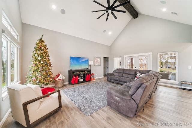 living room featuring ceiling fan, light hardwood / wood-style flooring, high vaulted ceiling, and a healthy amount of sunlight