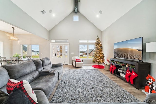 living room featuring hardwood / wood-style flooring, beamed ceiling, high vaulted ceiling, and a chandelier