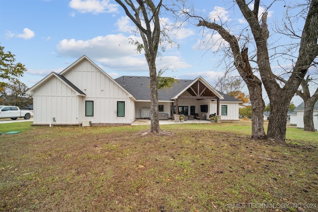 rear view of house featuring a lawn and a patio area