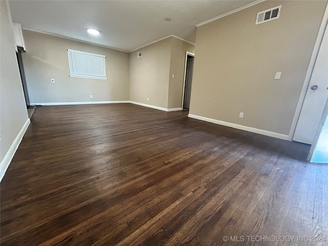 empty room with dark hardwood / wood-style flooring and ornamental molding