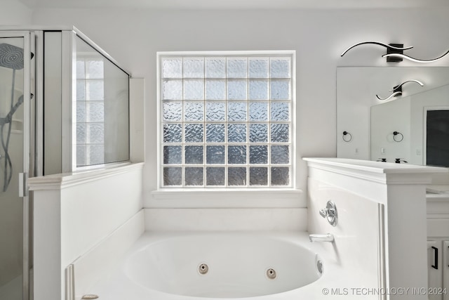 full bath featuring a tub with jets, a stall shower, and a wealth of natural light