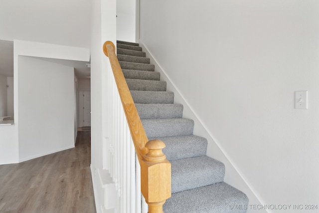 stairway with baseboards and wood finished floors