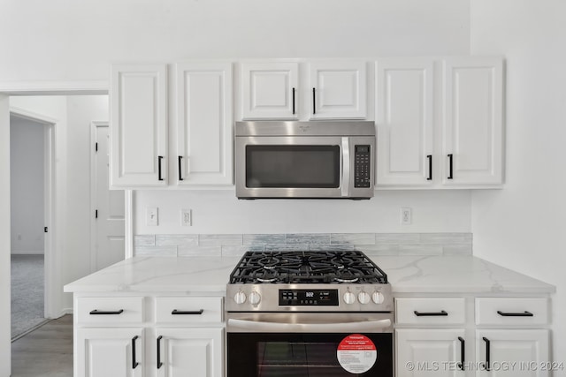 kitchen with white cabinetry, light stone countertops, and stainless steel appliances