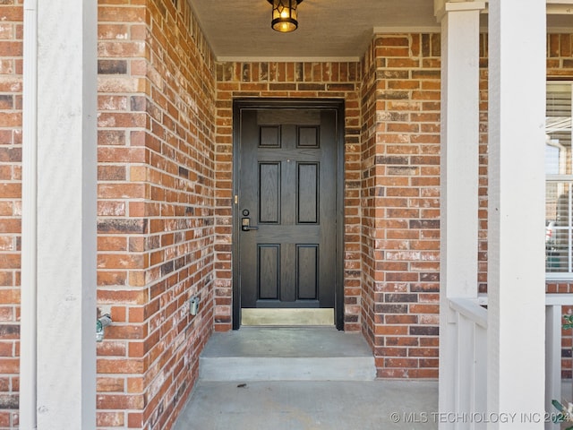 entrance to property featuring brick siding