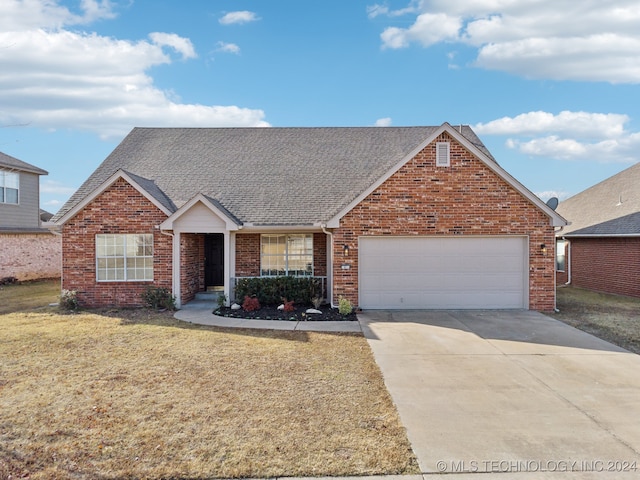 view of front of house with brick siding, a shingled roof, a front yard, a garage, and driveway