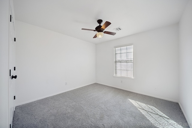 carpeted spare room featuring visible vents, baseboards, and a ceiling fan