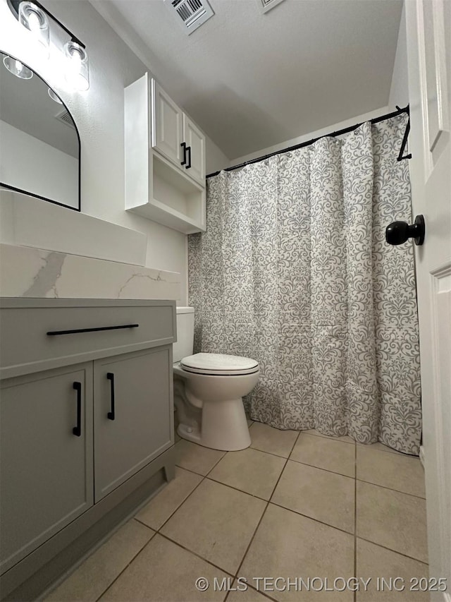 bathroom featuring vanity, tile patterned floors, toilet, and visible vents