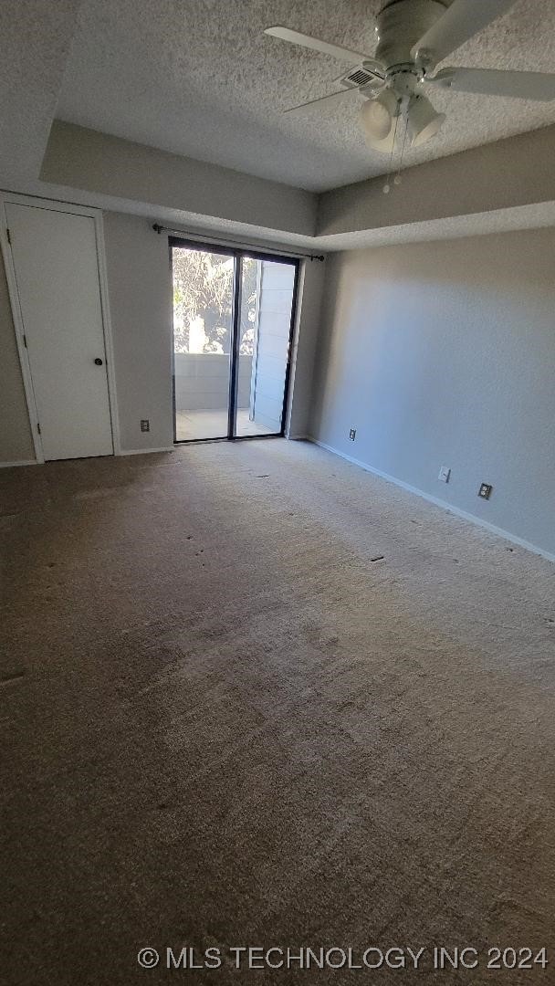 unfurnished room with baseboards, ceiling fan, a textured ceiling, and carpet flooring