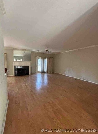 unfurnished living room with crown molding and wood-type flooring