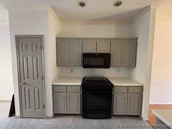 kitchen featuring light tile patterned floors, gray cabinetry, crown molding, and black appliances