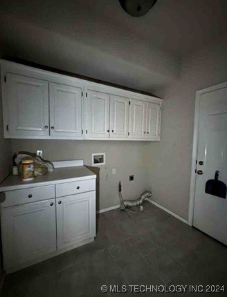 washroom featuring cabinets, hookup for a washing machine, dark tile patterned floors, and hookup for an electric dryer