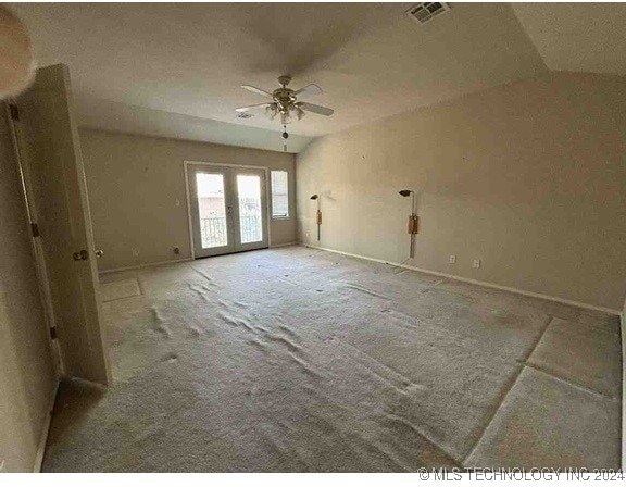 carpeted empty room featuring ceiling fan and vaulted ceiling