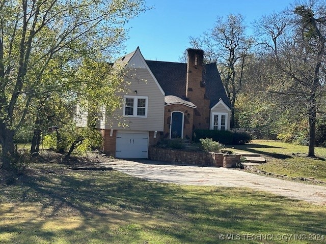 view of front of house featuring a garage and a front lawn