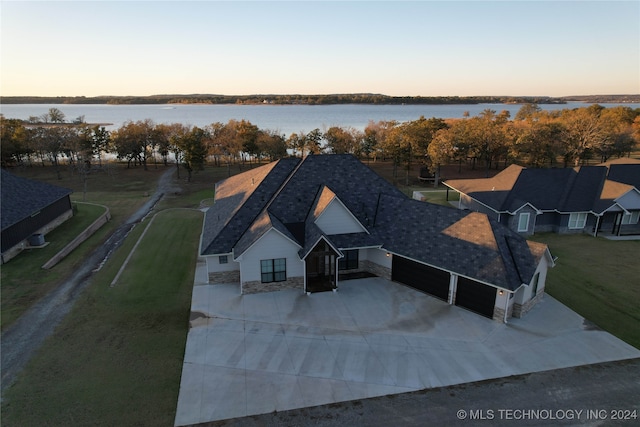 aerial view at dusk featuring a water view