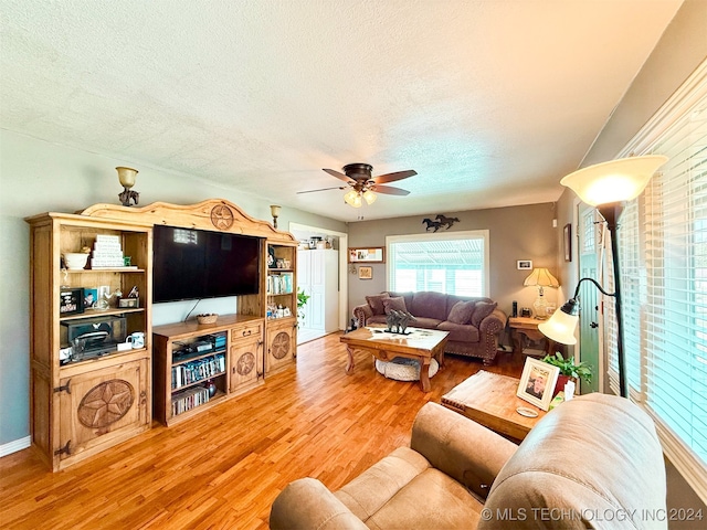 living room with a textured ceiling, hardwood / wood-style flooring, and ceiling fan