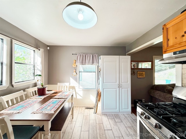 kitchen with light hardwood / wood-style floors, stainless steel range with gas cooktop, and a healthy amount of sunlight